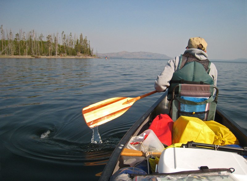 Canoeists paddling on a calm lake in Yellowstone National Park
