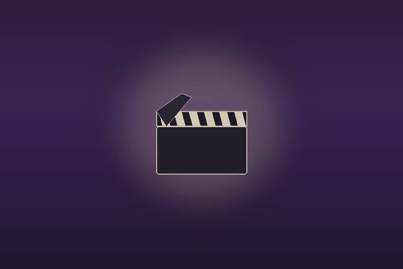 Movie clapperboard on a dim stage under a soft spotlight