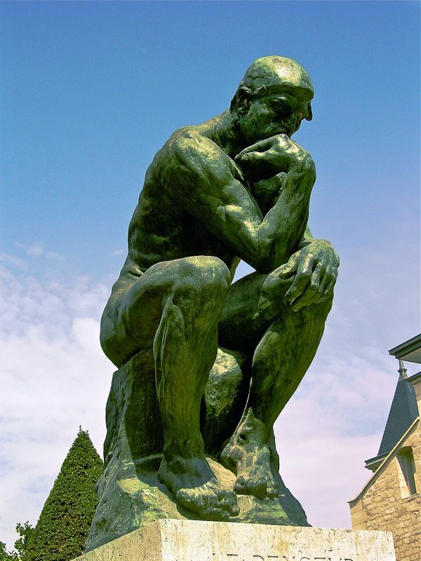 Bronze statue of The Thinker by Auguste Rodin, seated with chin resting on hand