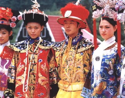 People wearing traditional Manchu court costumes in the style of the Qing royal family