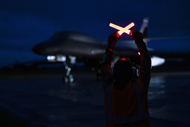 A U.S. Air Force crew chief marshals a B-1B Lancer bomber at RAF Fairford in England