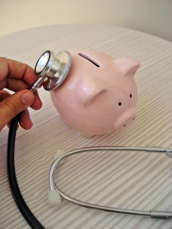 Stethoscope resting on a pink piggy bank, representing health savings accounts