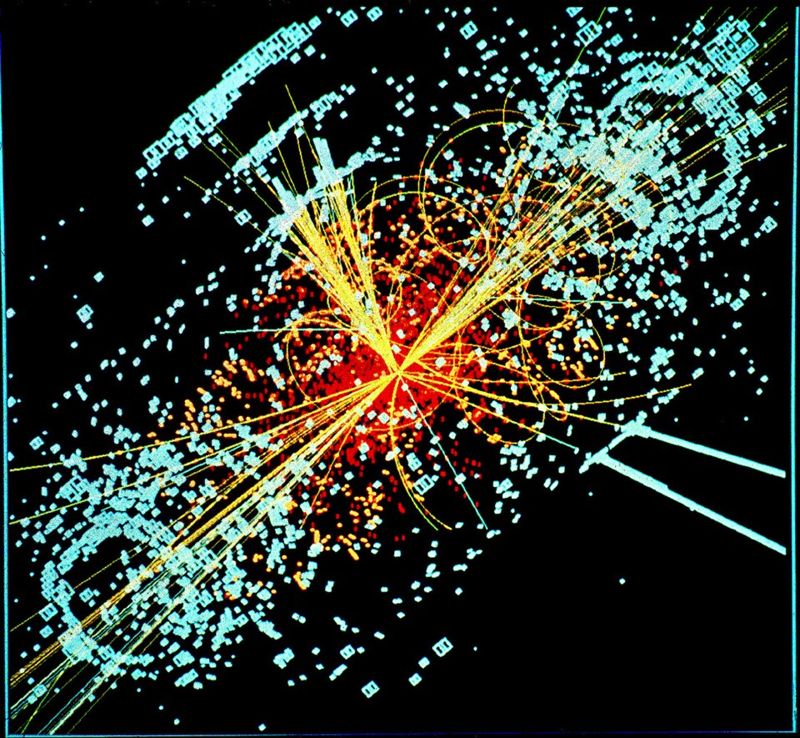 Particle collision event display from the CMS detector, with yellow particle tracks radiating from a central point