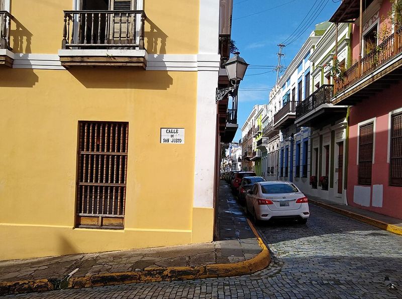 Colorful colonial buildings and a blue-cobblestone street at the corner of Calle San Justo in Old San Juan, Puerto Rico