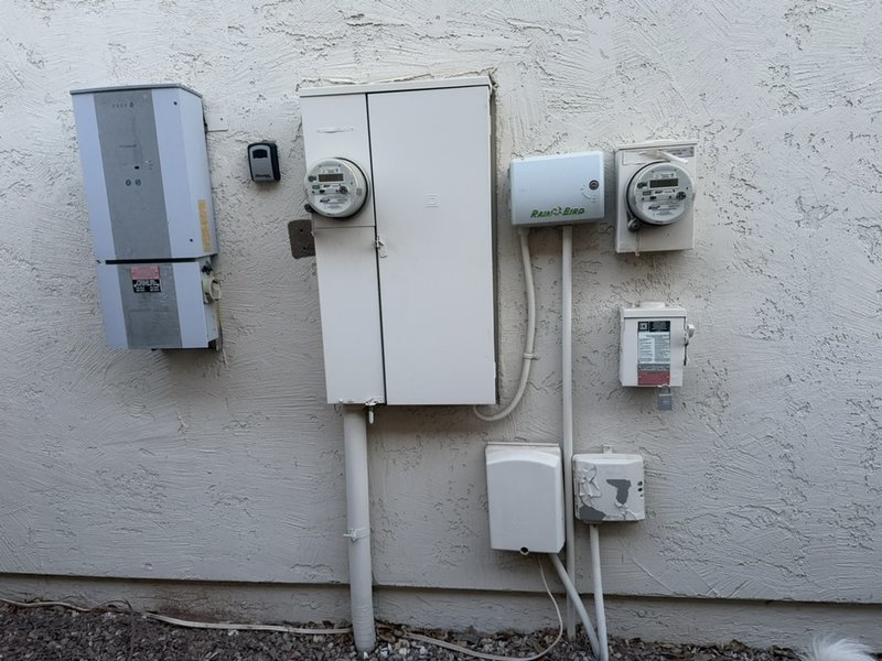 Residential electrical service entrance with meters and wiring on a building wall