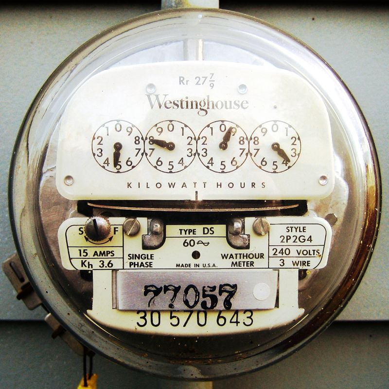 Close-up of an analog Westinghouse household electricity meter with dials measuring kilowatt hours