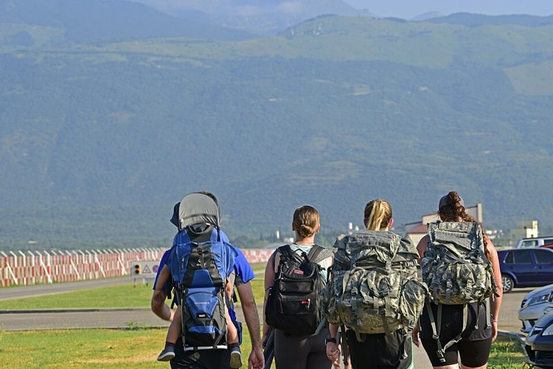 Group walking on a path while wearing loaded rucksacks and backpacks
