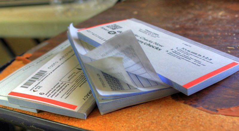 Stack of personal checkbooks, illustrating how to write a check