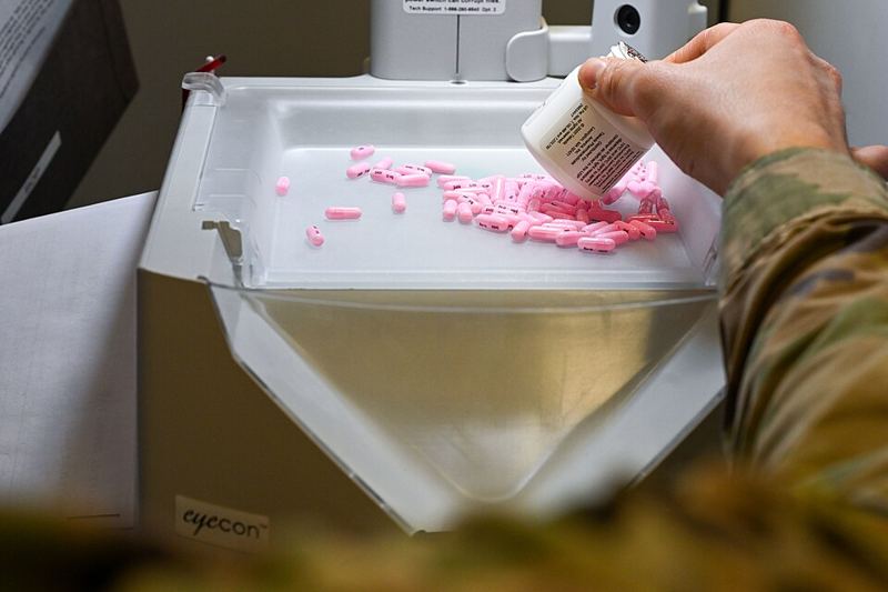 Pharmacist filling prescription orders with an automated pill counter