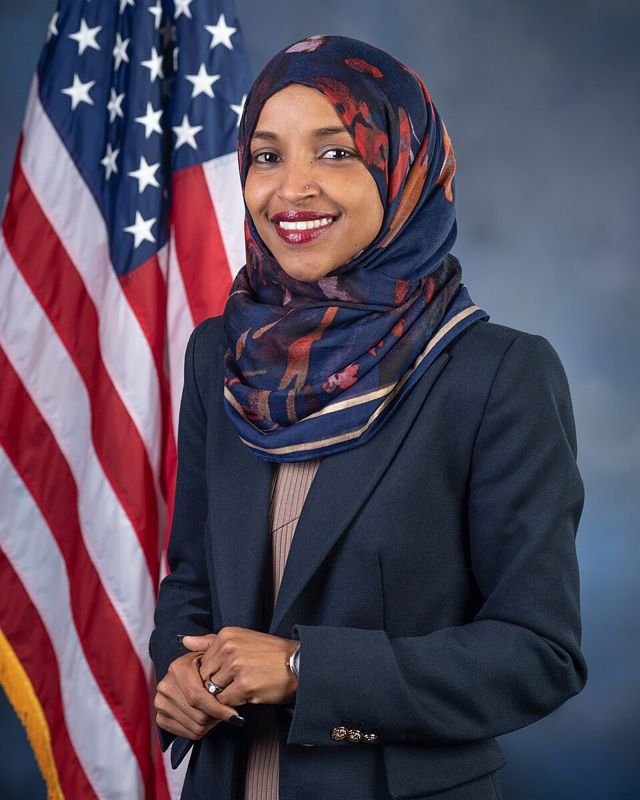 Official portrait of Rep. Ilhan Omar in front of a U.S. flag