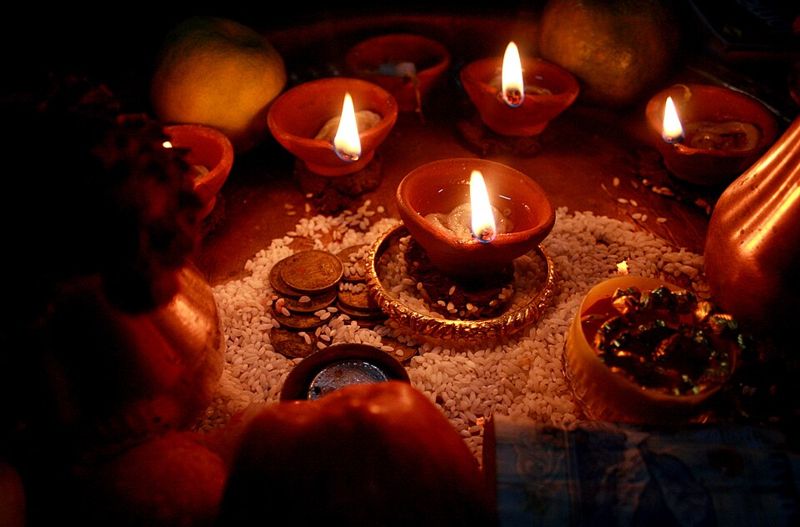 Lit clay diya oil lamps arranged on rice for Diwali