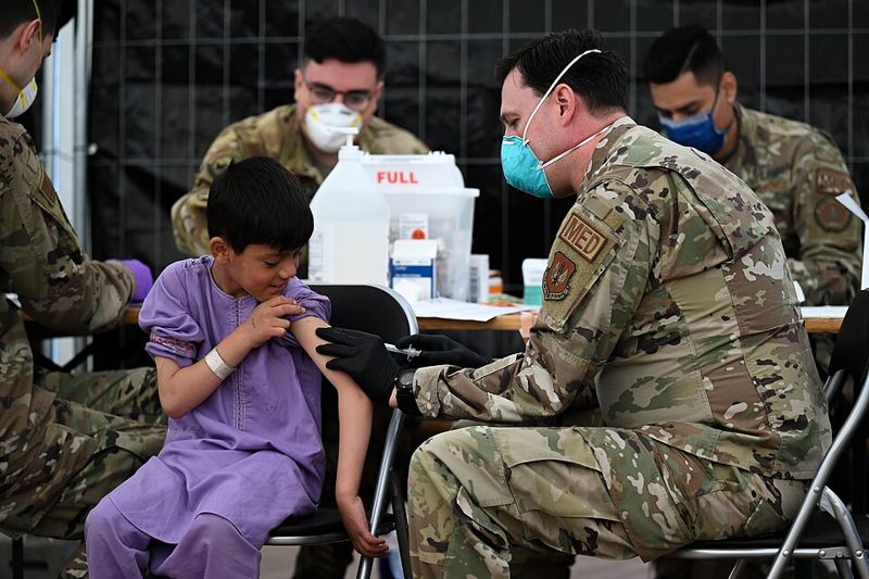 Medical worker gives a child an MMR vaccine shot in the arm