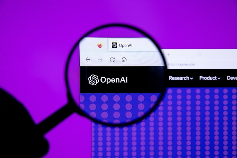 Magnifying glass over the OpenAI logo on the openai.com website in a browser window, illustrating OpenAI's GPT-6.1 Terra model