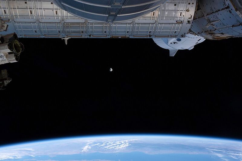 SpaceX Cargo Dragon spacecraft approaching the International Space Station above Earth