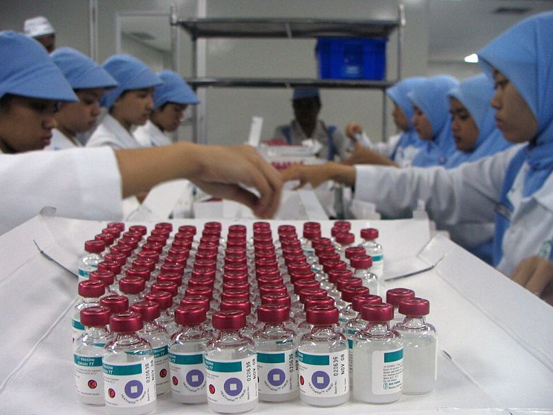 Workers inspecting vaccine vials at the Bio Farma plant in Bandung, Indonesia (public domain photo by Ümit Kartoğlu for VOA, via Wikimedia Commons)