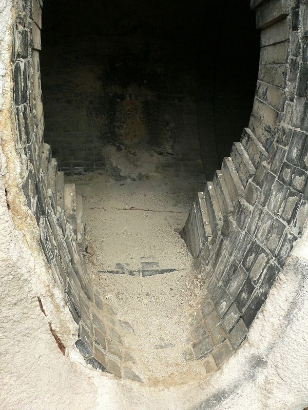 Interior of a torpedo car lined with dark refractory firebricks for hauling molten iron
