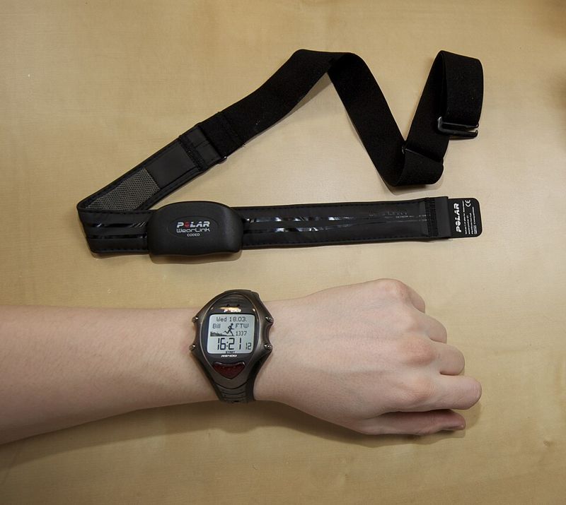 Polar chest-strap heart rate sensor and wrist training computer on a table