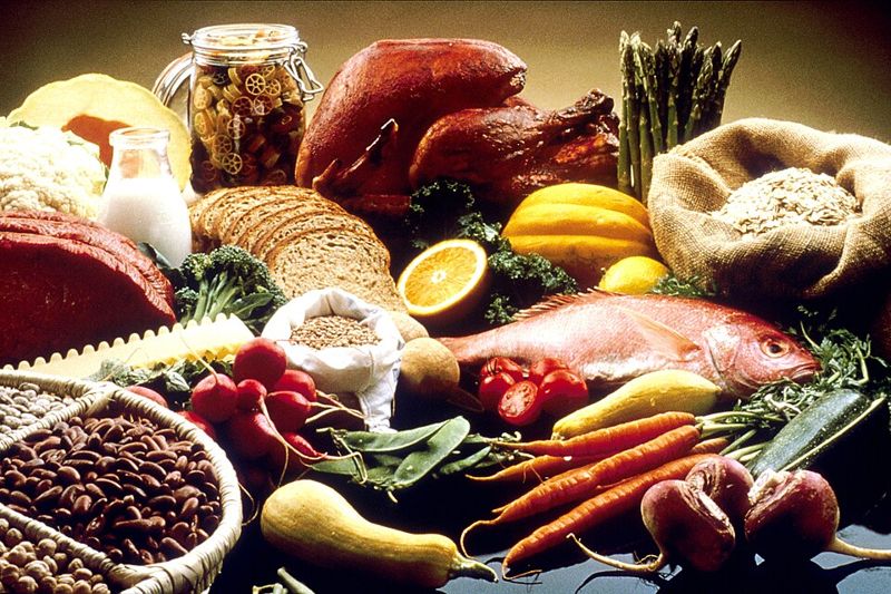 A table of whole foods including fish, turkey, bread, beans, grains, milk, vegetables, and fruit