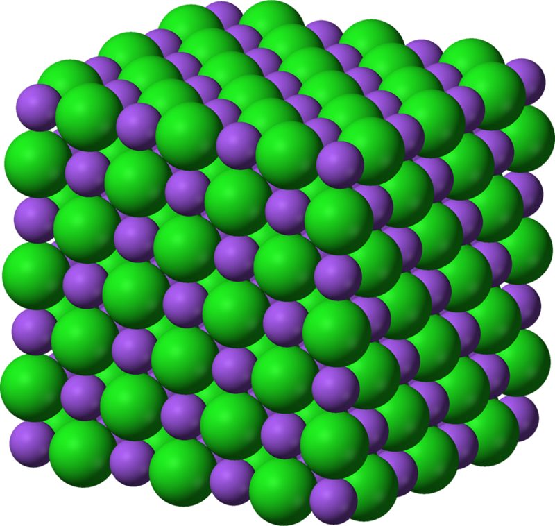 3D model of a sodium chloride crystal lattice with alternating green chloride ions and purple sodium ions