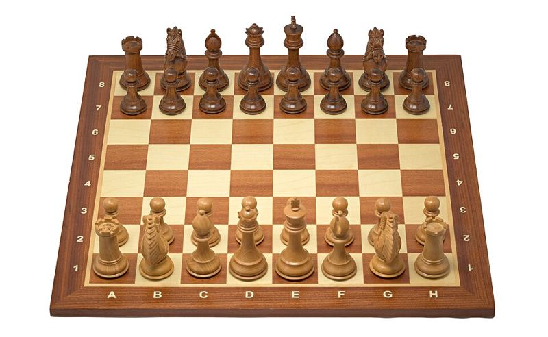 Wooden Staunton chess set arranged in the starting position on a chessboard
