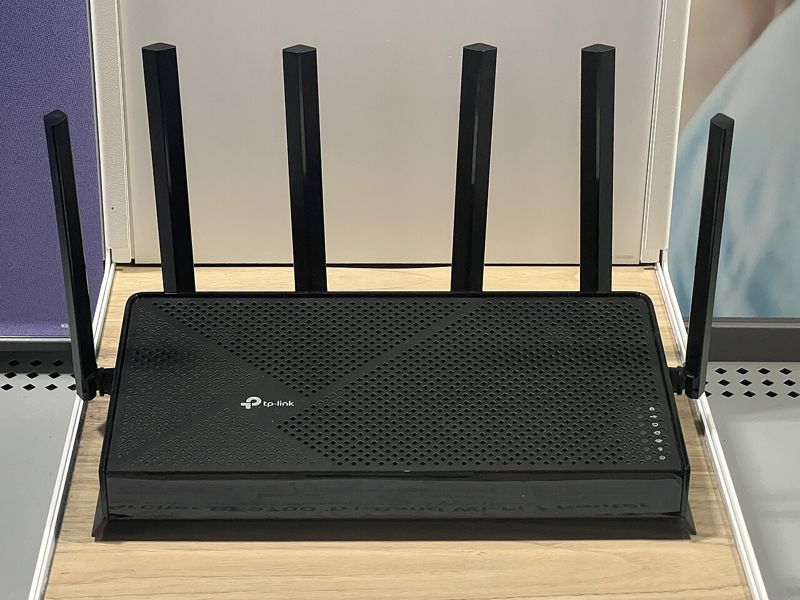 Black TP-Link Archer BE9700 tri-band Wi-Fi 7 router with six antennas on a store shelf