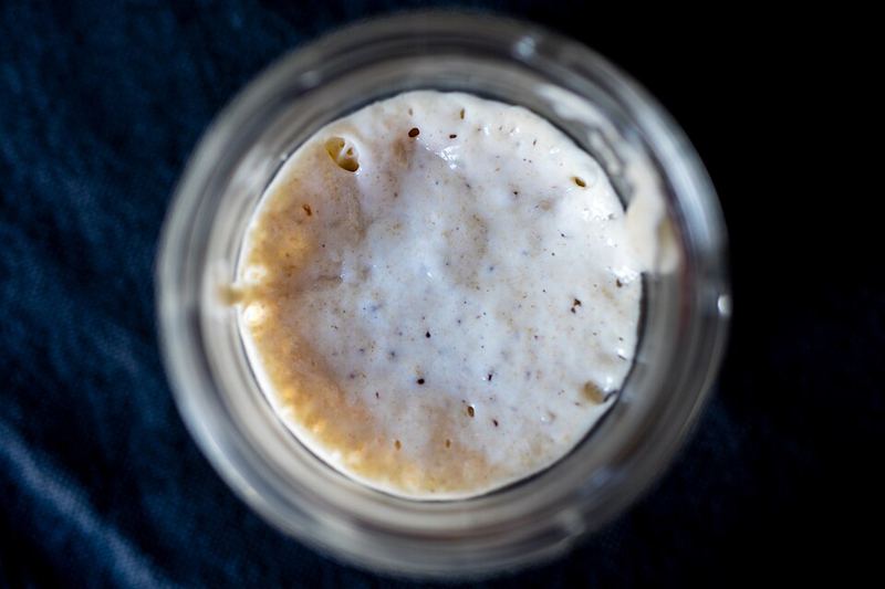Bubbly active sourdough starter in a glass jar, seen from above