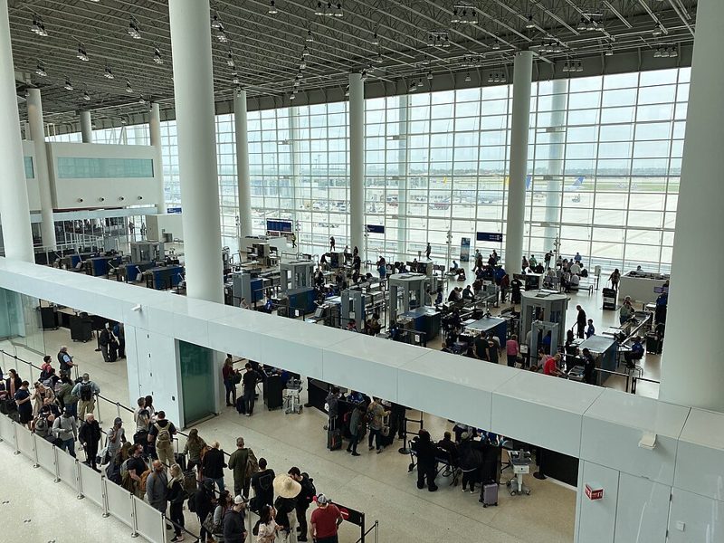 Long lines of travelers waiting at a TSA security checkpoint in the main terminal of New Orleans airport