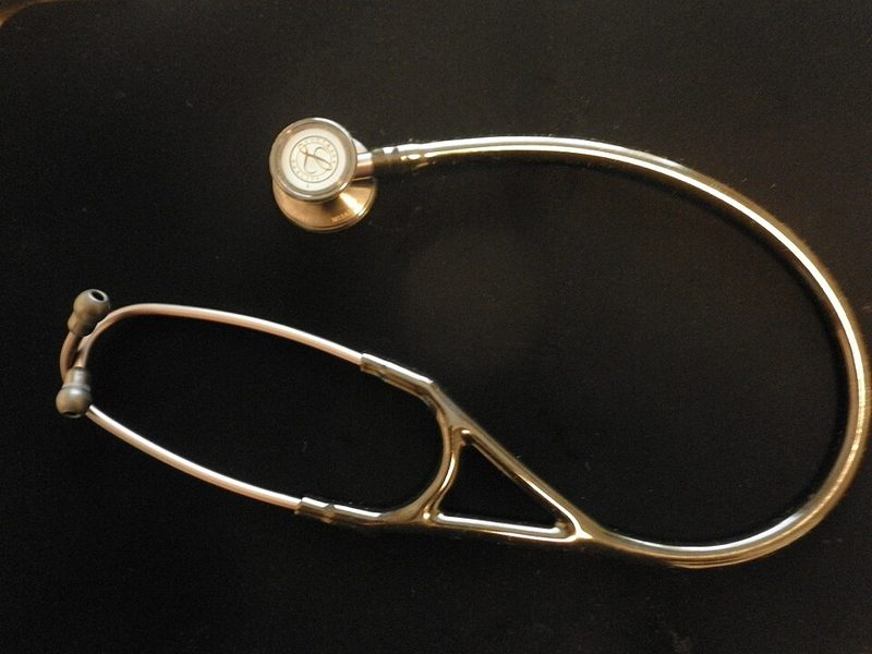 Stainless steel stethoscope lying on a black background
