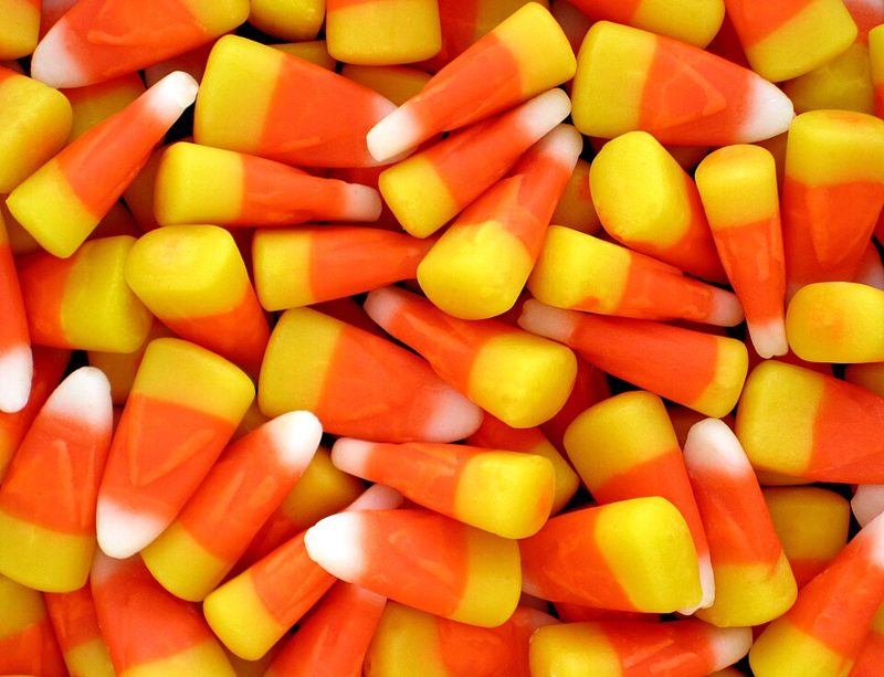 A pile of orange, yellow and white candy corn kernels
