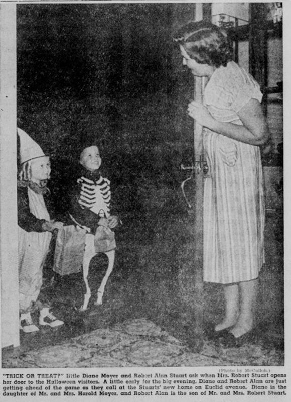 1950 newspaper photo of two costumed children trick-or-treating at a front door