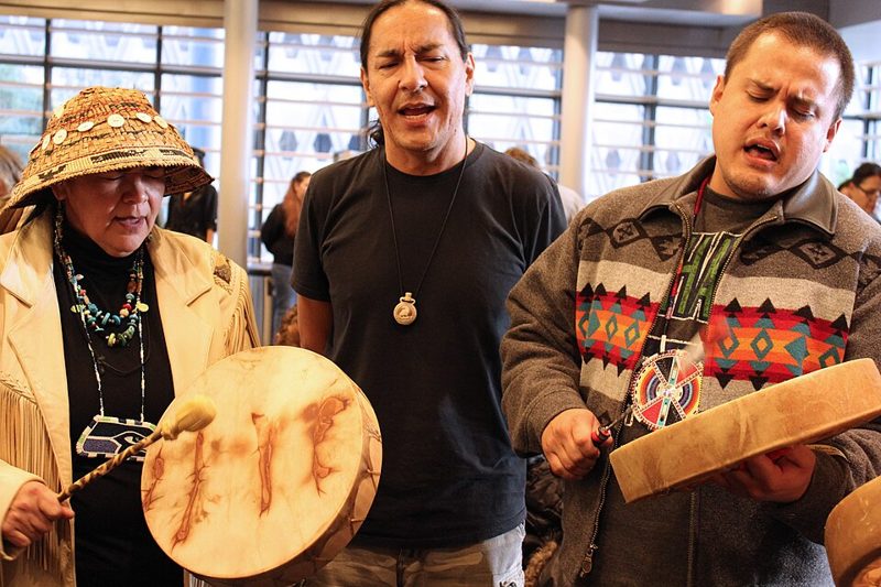Indigenous performers singing and playing hand drums at an Indigenous Peoples’ Day event at Seattle City Hall in 2014