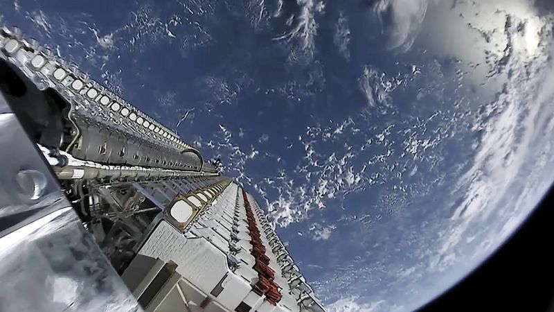 A stack of SpaceX Starlink satellites in orbit above Earth before deployment